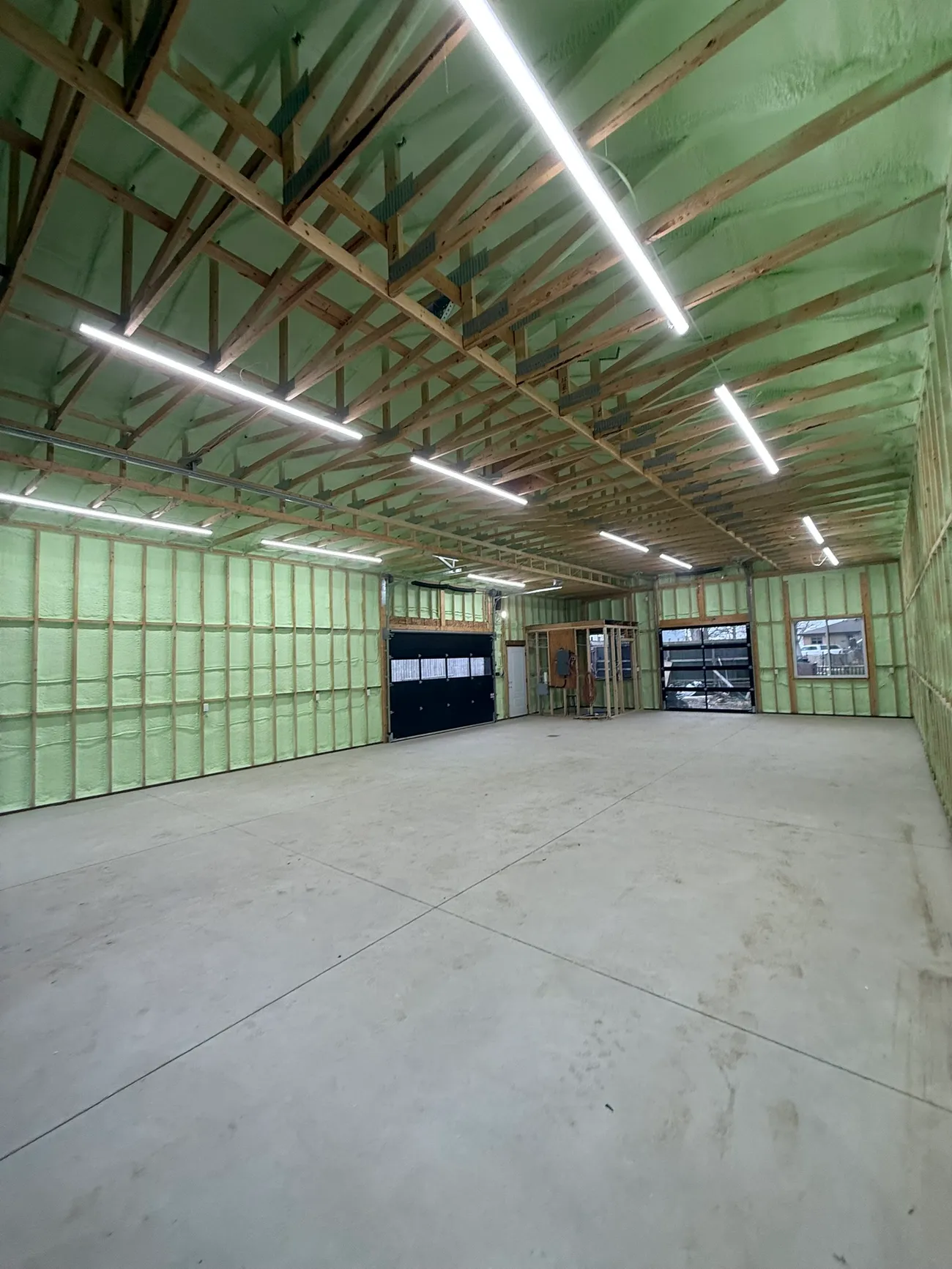 Pole barn interior with closed-cell spray foam on steel panel walls and roof
